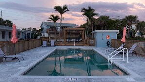 A swimming pool with a wooden deck, lounge chairs, and a lifebuoy. - #8 Beach Access King Studio (Sarasota County)