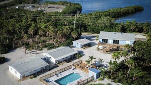 A beachfront property with a swimming pool, multiple buildings, and a dock. - #8 Beach Access King Studio (Sarasota County)