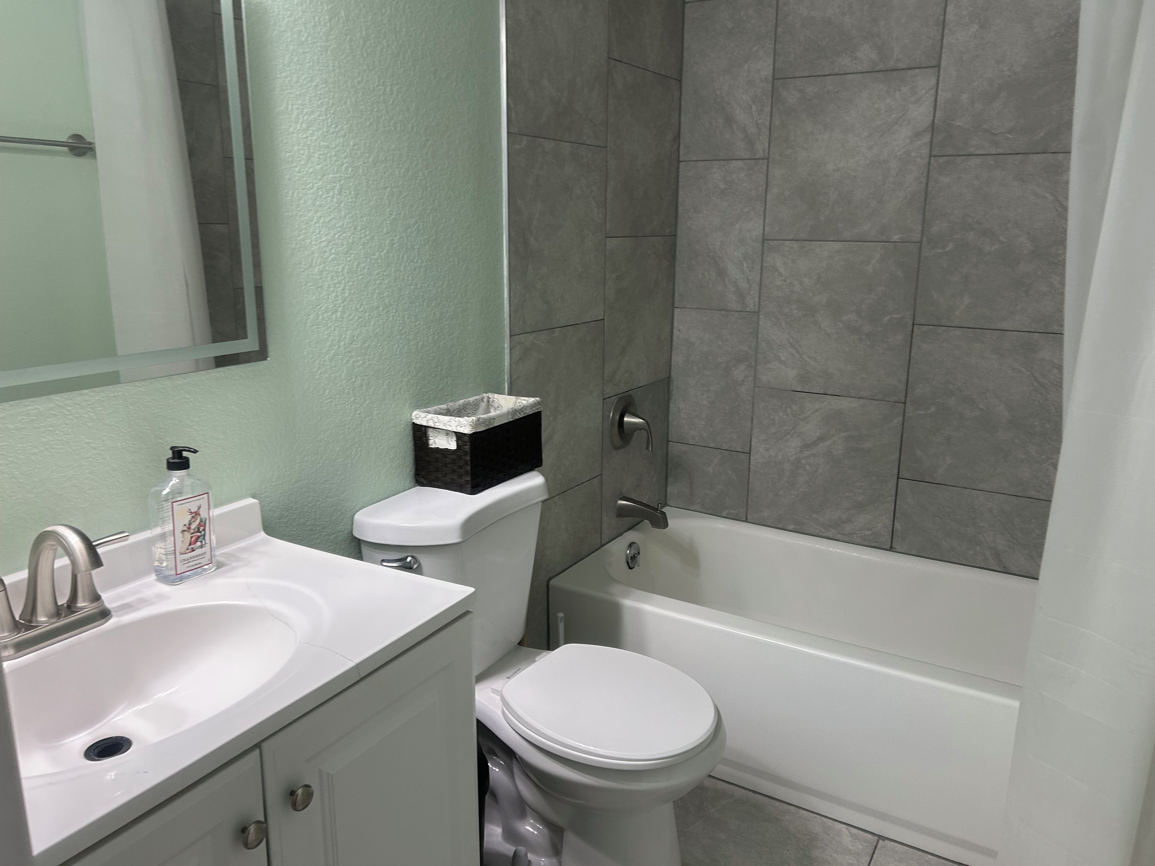 Ein Badezimmer mit einem weißen Waschbecken, einer Toilette und einer Badewanne.