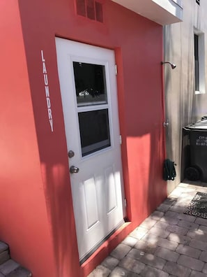 A red building with a white door, a window, and a small vent above the door. - Sun & Sand Retreat 1BR 1BA (Hollywood)