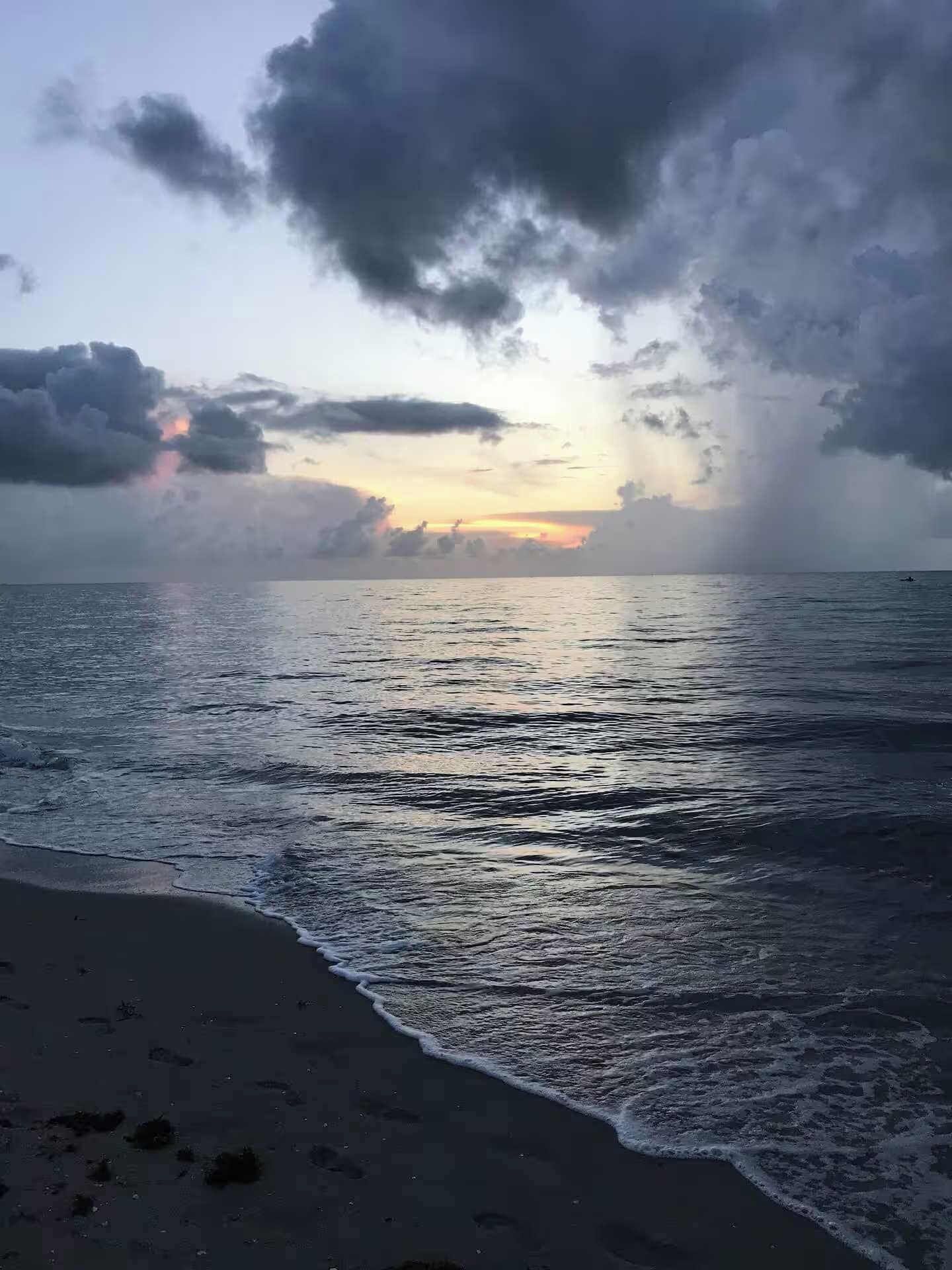 Uma praia com ondas e céu nublado.