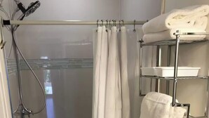 Une salle de bain avec une douche, des toilettes et un porte-serviettes.