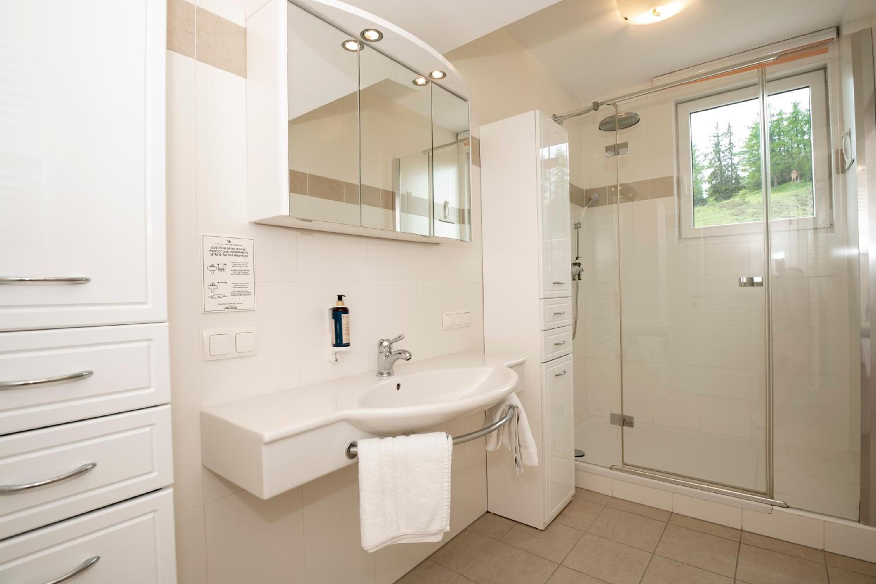 Ein modernes Badezimmer mit Waschbecken, Spiegel und Dusche.