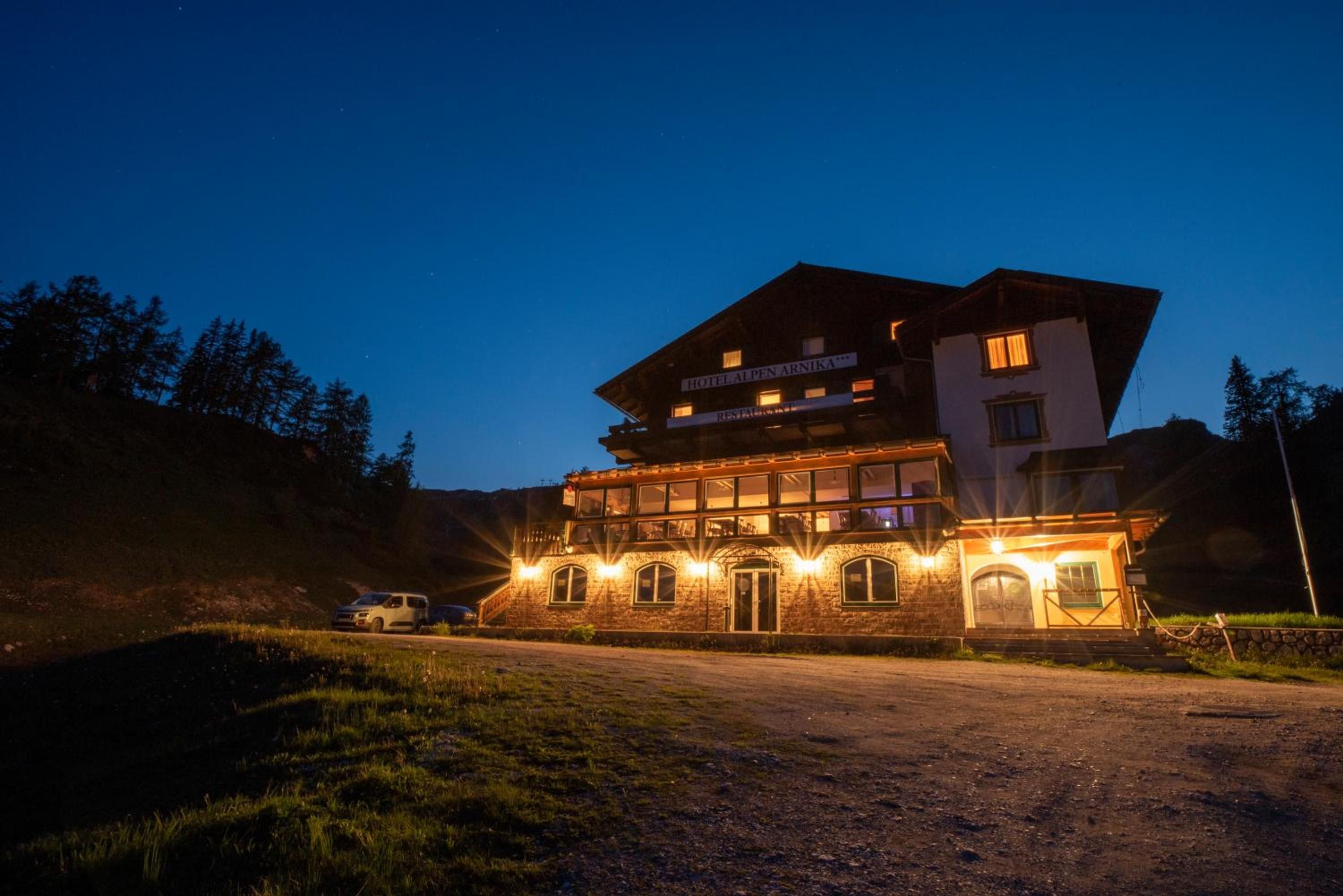 Ein mehrstöckiges Hotel mit Restaurant im Erdgeschoss, eingebettet in eine natürliche Landschaft.