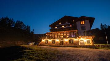 Ein mehrstöckiges Hotel mit Restaurant im Erdgeschoss, eingebettet in eine natürliche Landschaft.