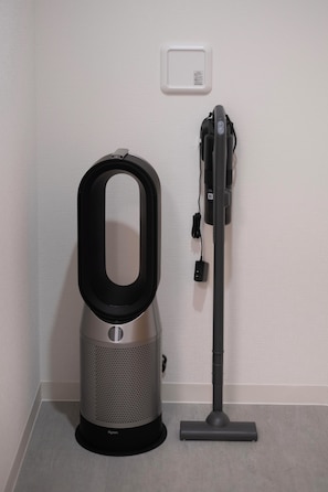 Ein Dyson Staubsauger und ein Dyson Akkusauger vor einer Wand.