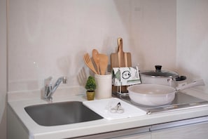 A kitchen with a sink, a cutting board, a pot, and wooden utensils. - The Peak Shinsaibashi Reserve (Shimanouchi, Chuo-ku, Osaka-shi)