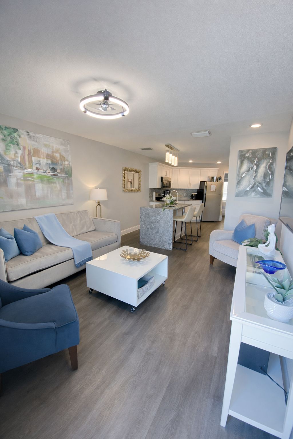A modern living room with a sofa, coffee table, and a dining area with chairs.