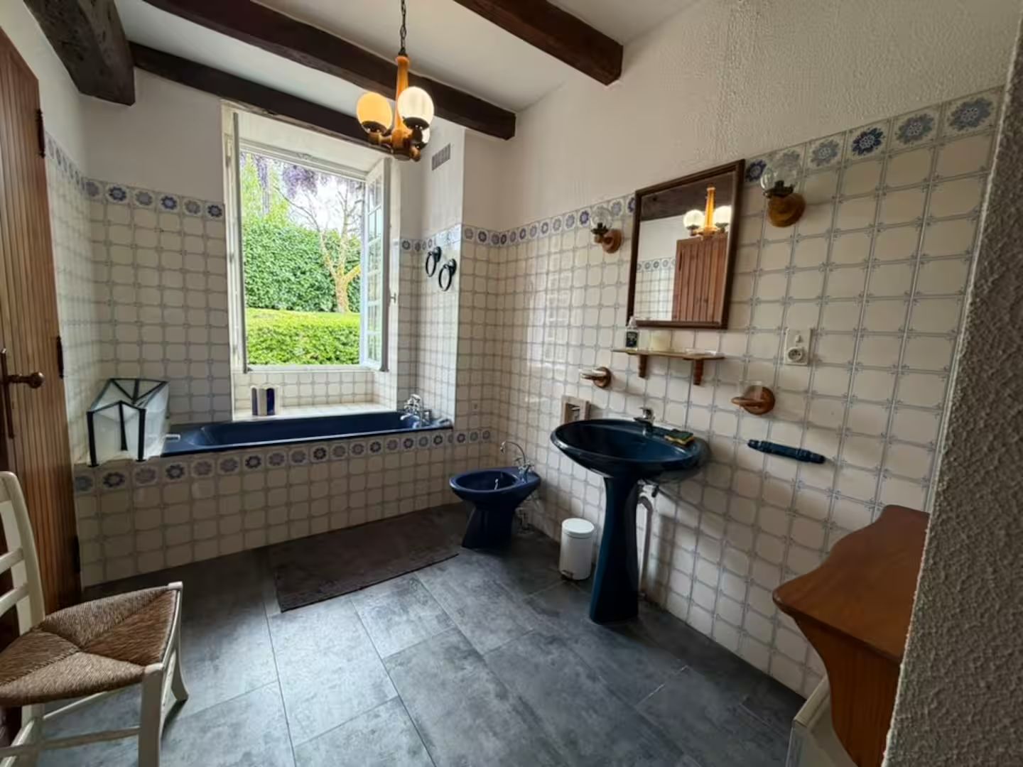 Een badkamer met een bad, een wastafel en een raam.