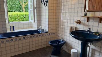 A bathroom with a bathtub, a bidet, and a sink.