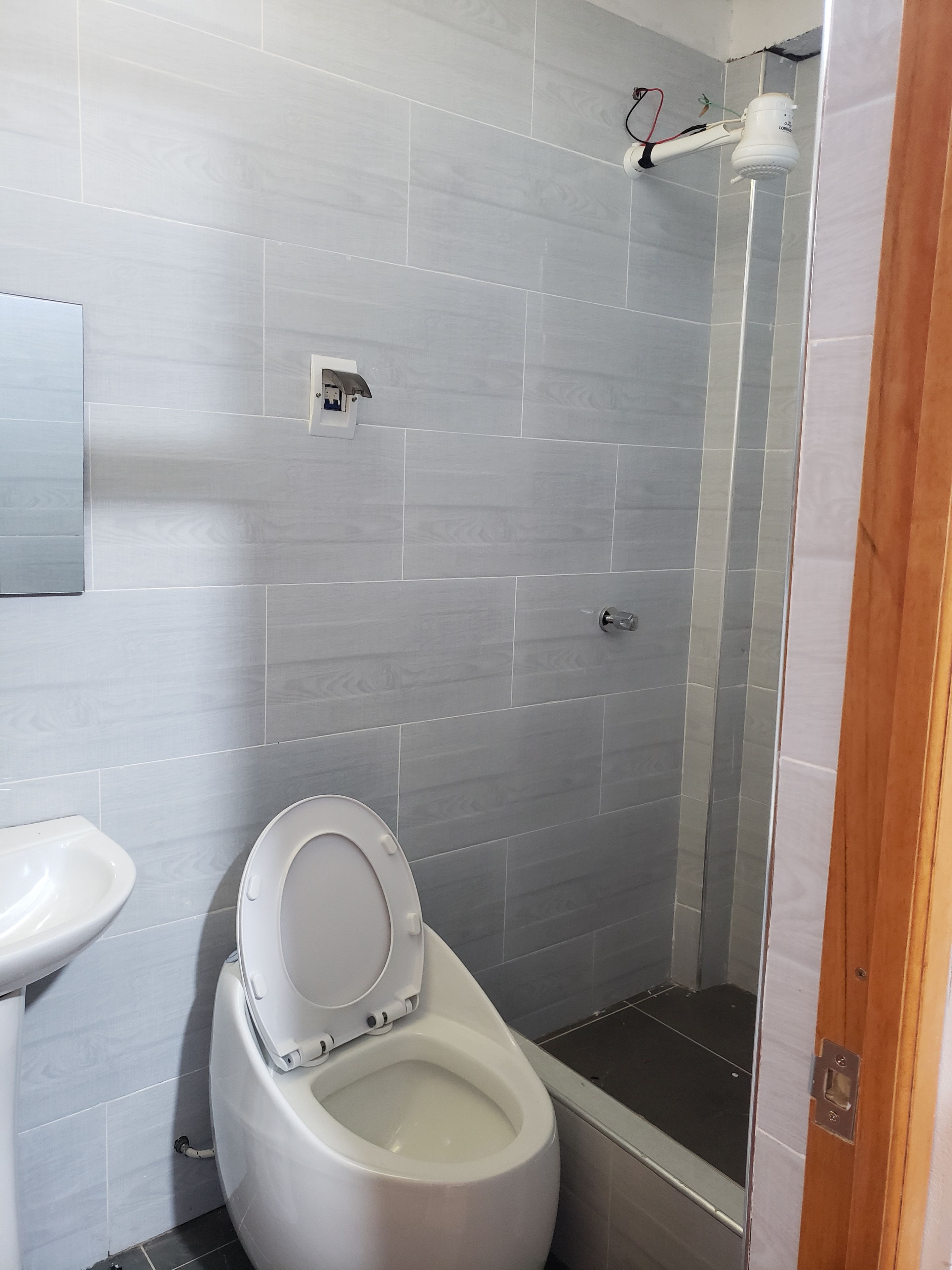 Een badkamer met toilet, bidet en douchecabine.