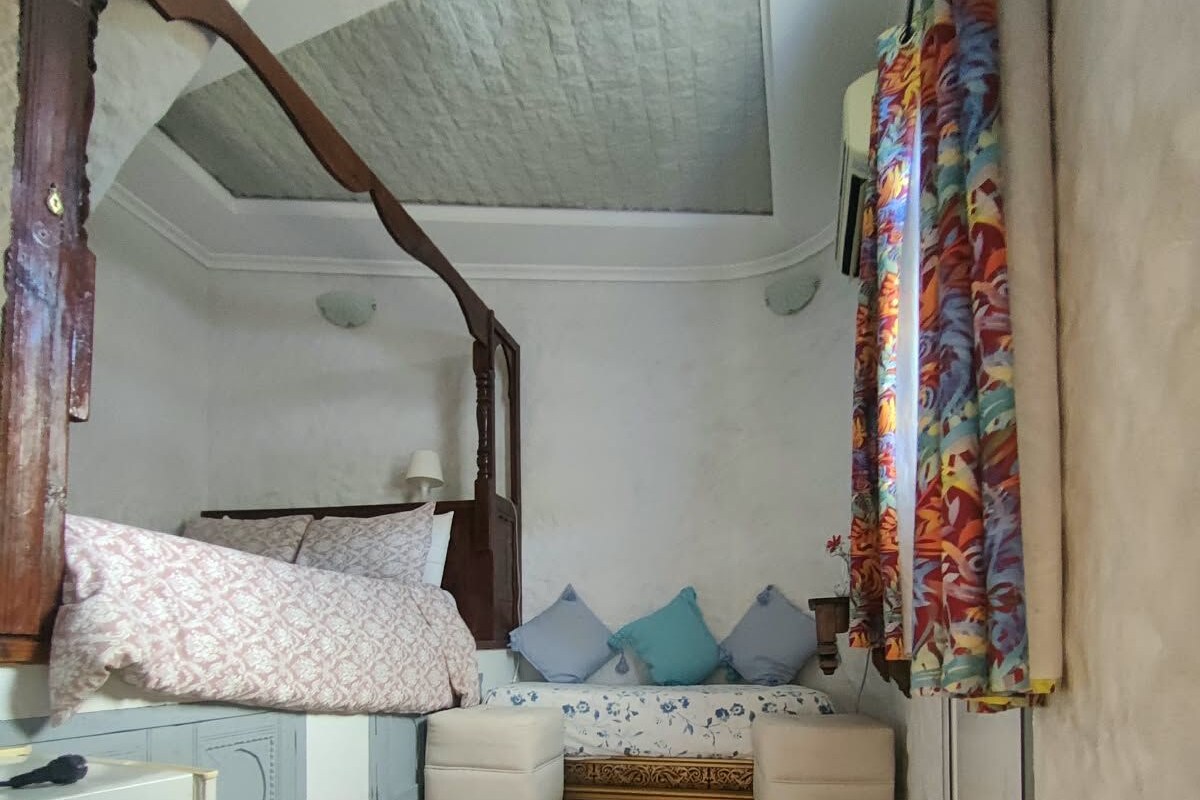 A bedroom with a bed, bedside tables, a wardrobe, and a small desk.