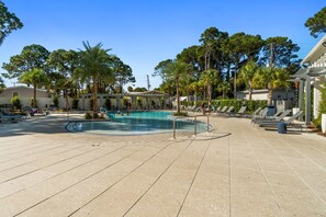 A pool area with a clear blue pool, surrounded by lounge chairs and palm trees. - New! Sandestin Cottage w/ Golf Cart, Pool, Beach Access, Dog Friendly & Fenced Yard (Miramar Beach)