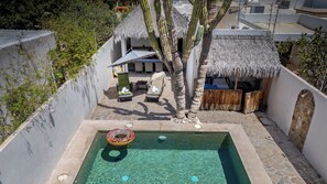 A swimming pool with a donut float, a thatched-roof structure, and a stone wall. - Casa Cactus with a heated pool for 7 people in Centenario. (El Centenario)