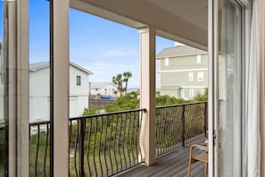 A covered outdoor area with a wooden deck, metal railing, and a view of neighboring houses. - ☀️ Seas the Day | Ocean Views | Steps 2 Beach | Private Pool | Free Golf (Miramar Beach)