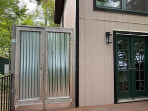 A building with a green door and a metal gate. - Fish Cabin – 1 Bedroom + Loft • Sleeps 6 • Lake & Beach Views • Access (La Pointe)