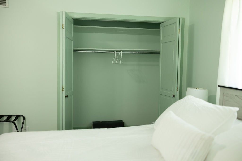 Ein Hotelzimmer mit einem Bett, einem Schrank und einem Nachttisch.