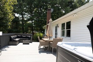 Una terraza con mobiliario exterior, un jacuzzi y una chimenea.