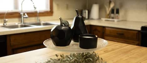 Una cocina con armarios de madera, un lavamanos y una encimera con un juego de té y hierbas.