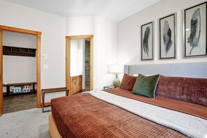 Ein Hotelzimmer mit einem großen Bett, einem Holzschrank, einem Spiegel und Bildern an der Wand.