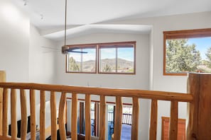 A room with a wooden railing, large windows, and a view of a mountainous landscape. - New Listing - Custom Furnishings - Ski Season Shuttle - Community Pool & Hot Tub (Steamboat Springs)