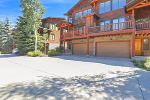 A two-story log cabin with a balcony, a garage, and a driveway. - New Listing - Custom Furnishings - Ski Season Shuttle - Community Pool & Hot Tub (Steamboat Springs)