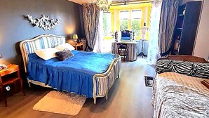 A bedroom with a large bed, a desk, and a chair. There is a window with curtains, a chandelier, and a wall-mounted decoration. - 2 vacation rentals in Burgundy for 11 people Nature, optional spa, and pets welcome! (Recey-sur-Ource)