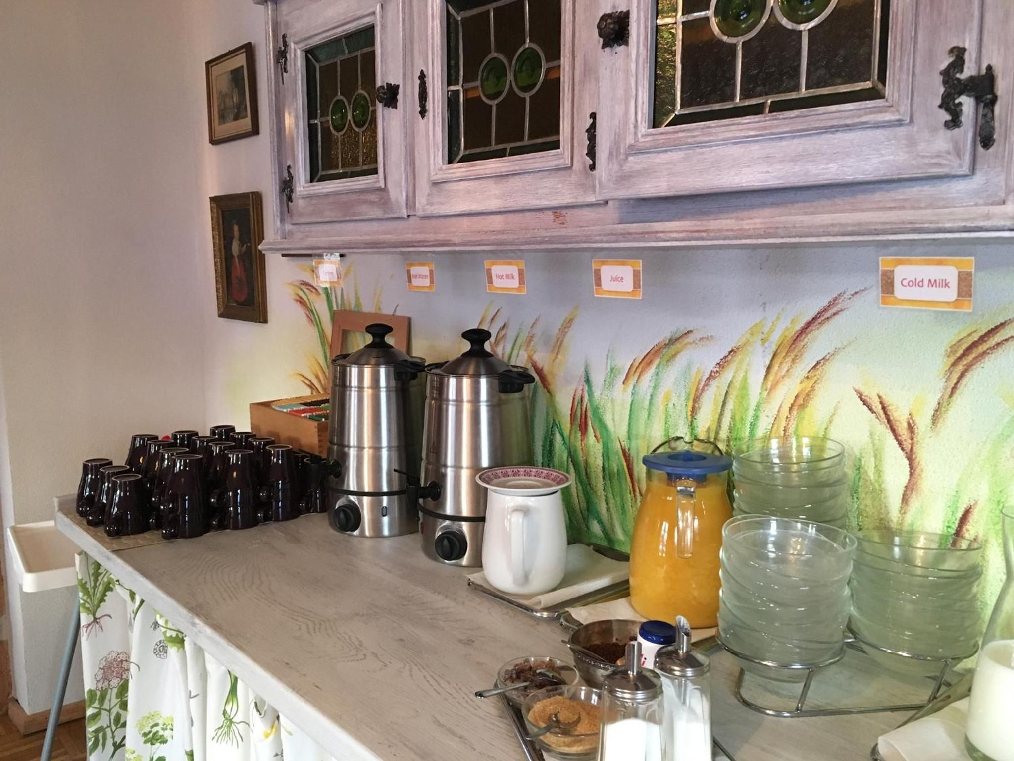 A kitchen counter with coffee makers, a kettle, and various containers for food items.