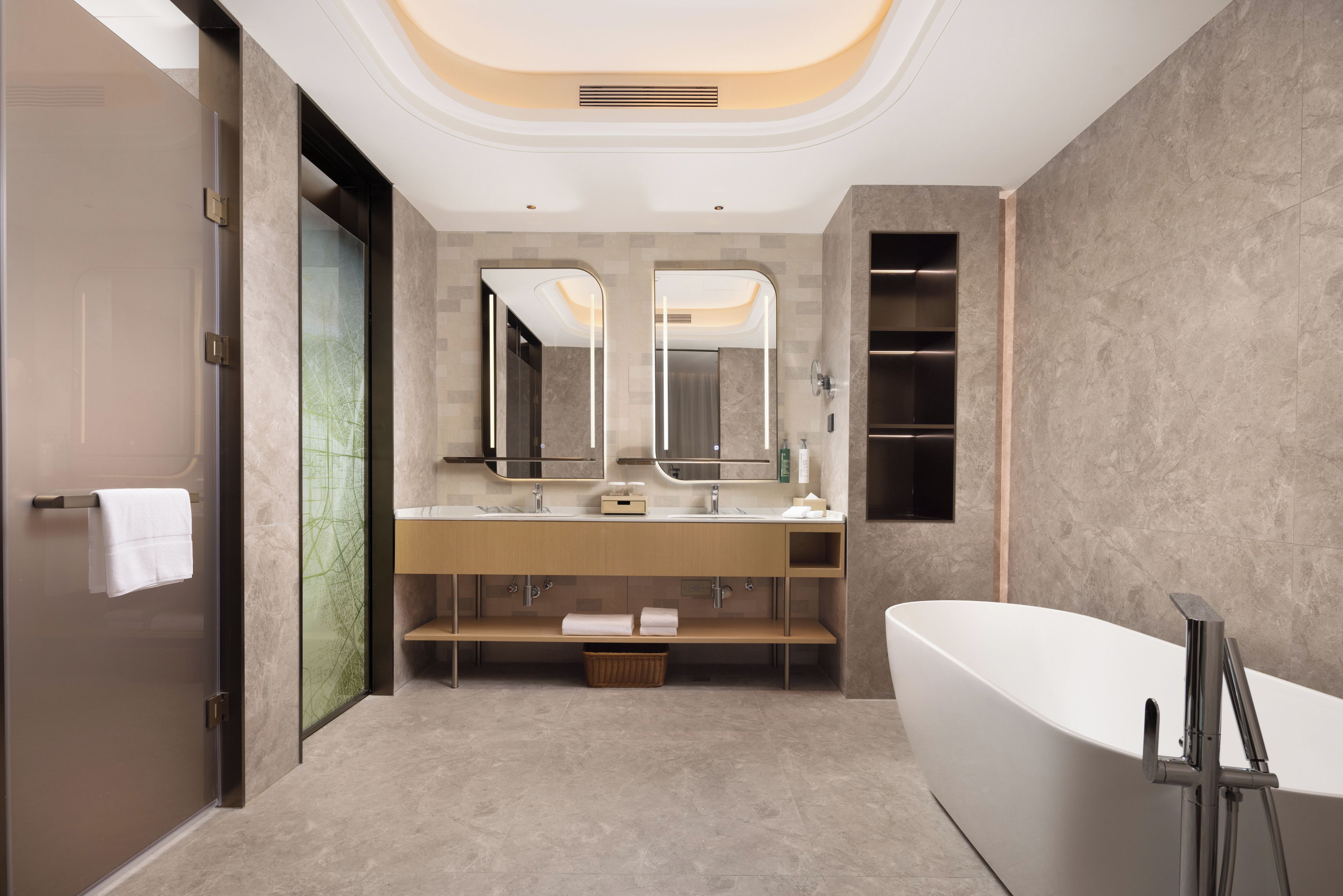 A modern bathroom with a freestanding bathtub, a double vanity with mirrors, and a large mirror above the sink.