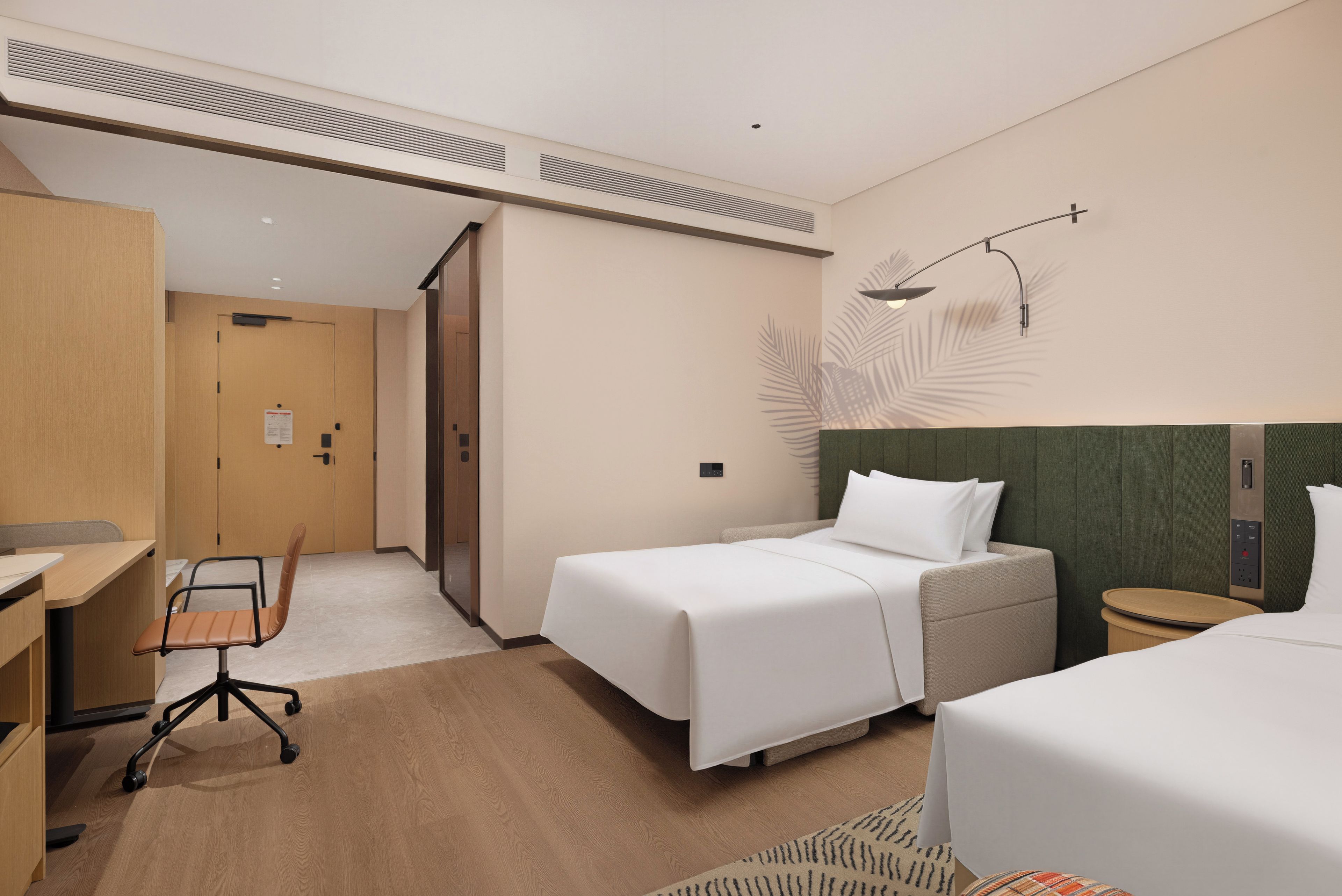 Ein Hotelzimmer mit einem Bett, einem Schreibtisch, einem Stuhl und einem kleinen Tisch.