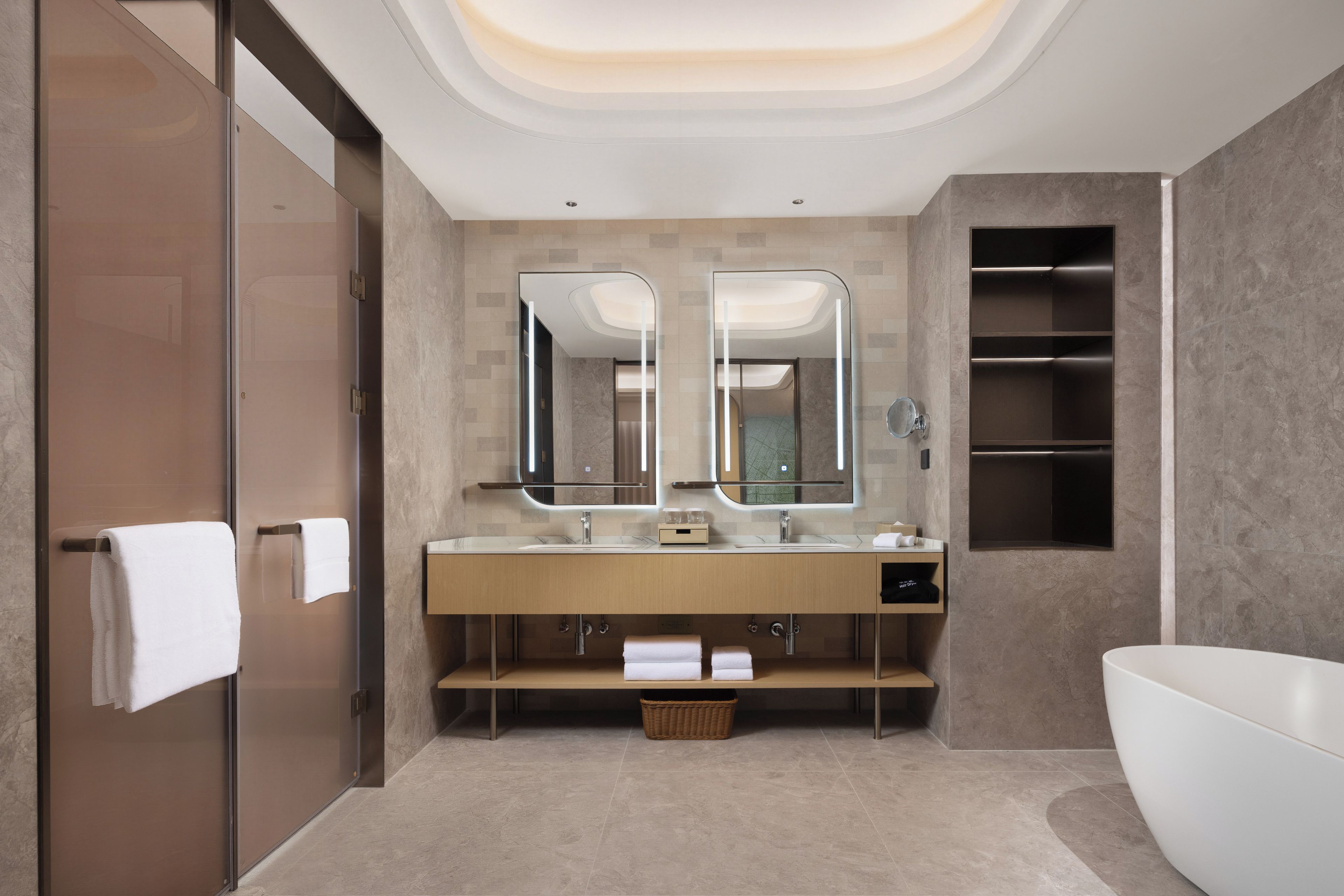 A modern bathroom with a double sink, a large mirror, a bathtub, and a walk-in shower.