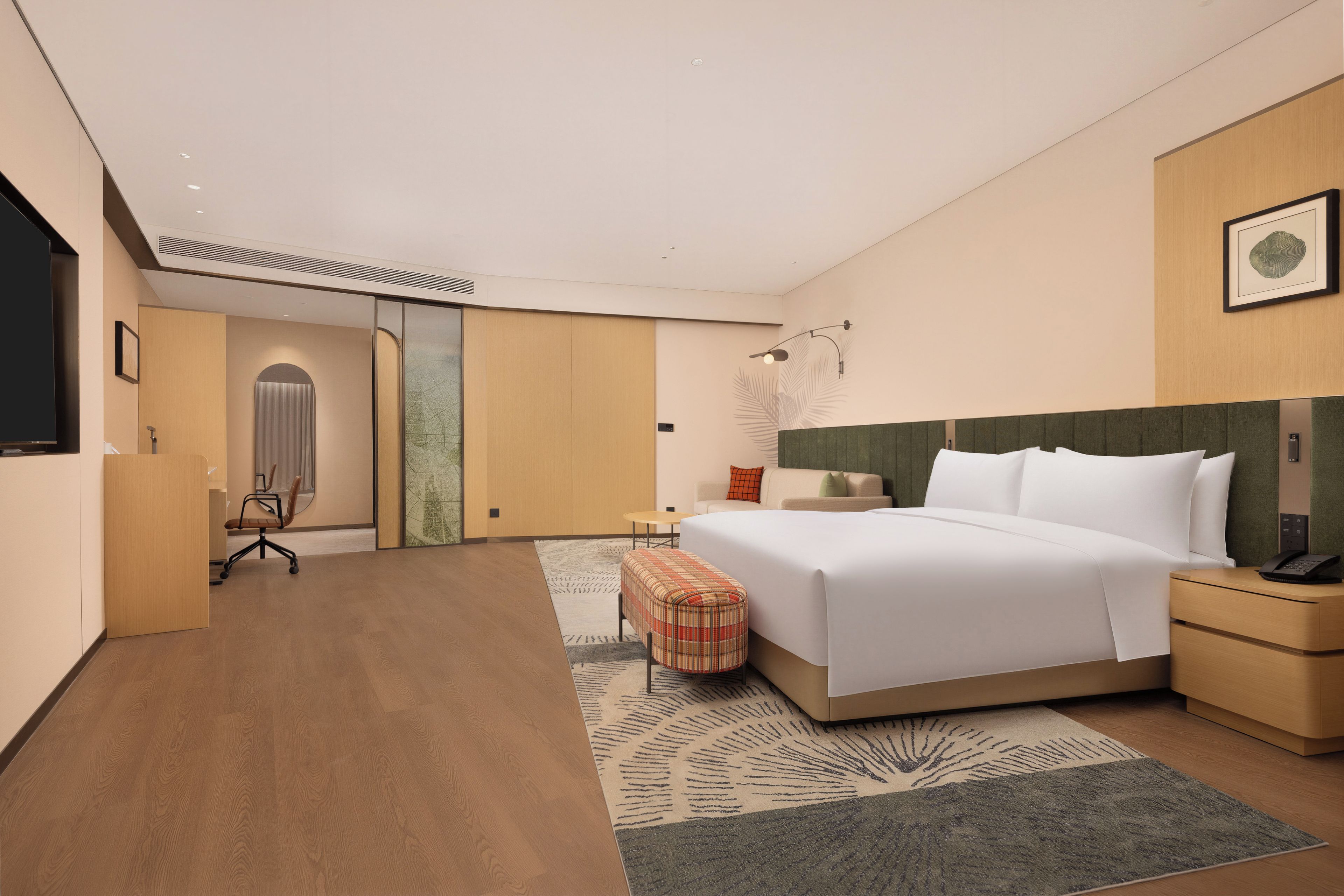 Een hotelkamer met een bed, nachtkastjes, een bureau, een stoel en een groot raam.