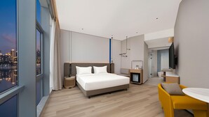 A modern hotel room with a large bed, a small desk, a chair, and a TV. - Holiday Inn Express Shanghai North Bund Riverside (Shanghai)