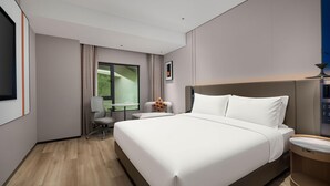 A hotel room with a large bed, a desk with a chair, a window with curtains, and a television mounted on the wall. - Holiday Inn Express Shanghai North Bund Riverside (Shanghai)