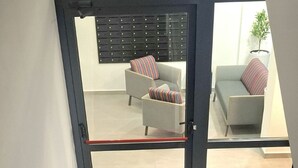 Una scala che conduce a una zona living con un divano e una pianta.