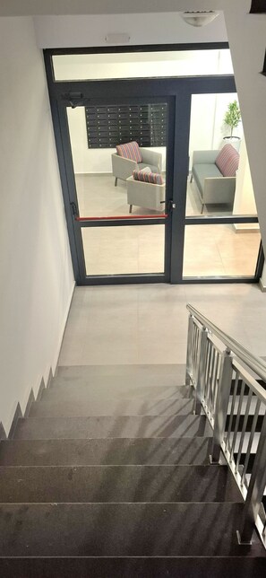 A staircase leading to a living area with a sofa and a plant. - Stylish Apartment with Large Green Terrace & Private Parking (Sofia)
