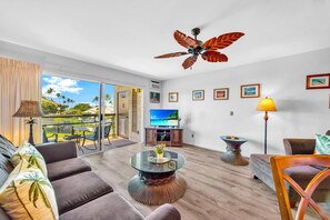 Ein modernes Wohnzimmer mit Fernseher, Sofa und Couchtisch.