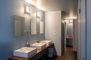 A modern bathroom with three sinks, mirrors, and a wooden vanity. - Dragon Inn Nikko (nikko)