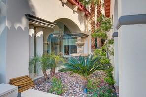 A courtyard with a fountain, palm trees, and a bench. - Spacious 5-bedroom house in charming guard gated golf course community! (Las Vegas)