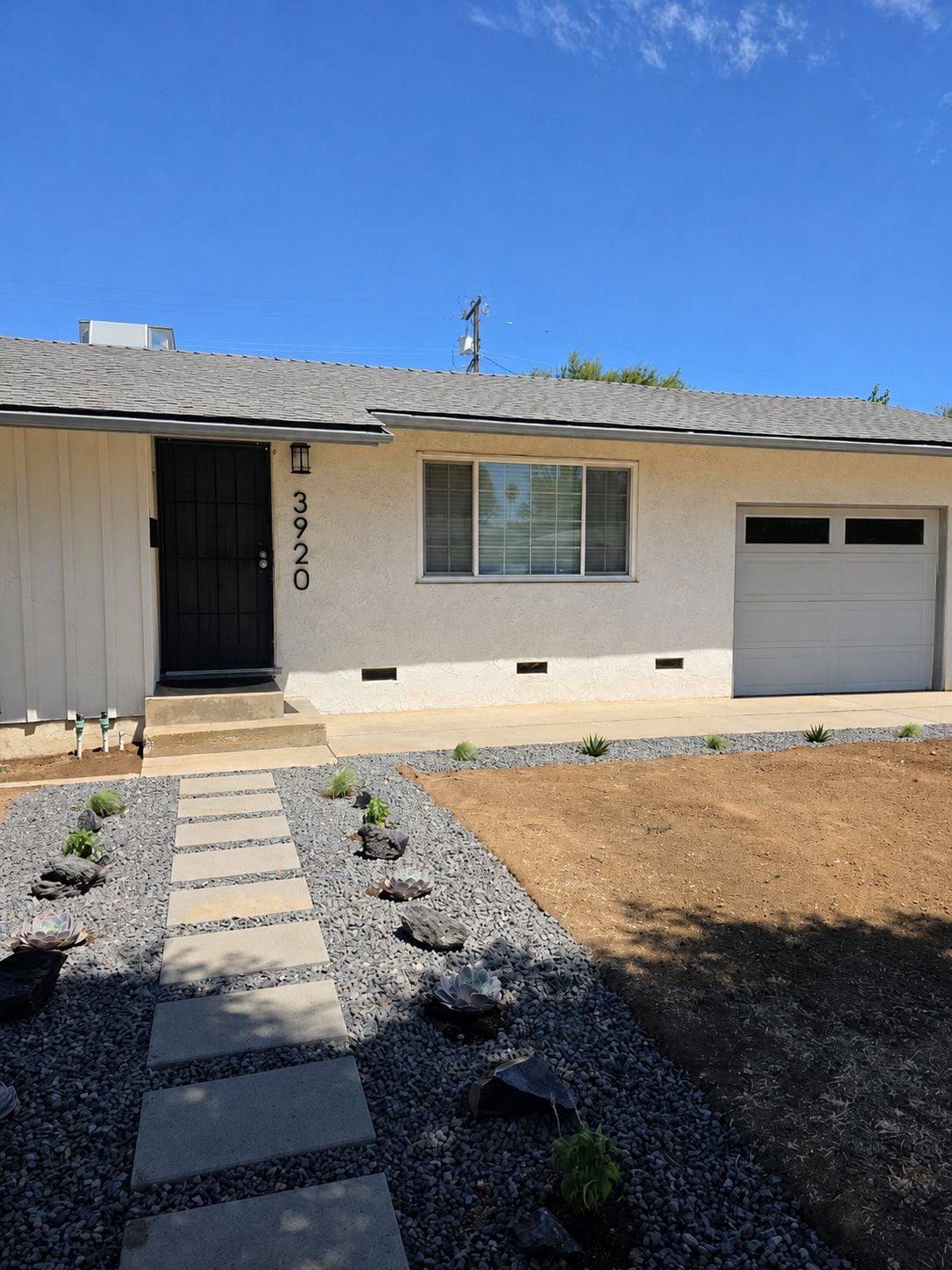 A single-story house with a garage, a front door, and a number '3920' on the wall.