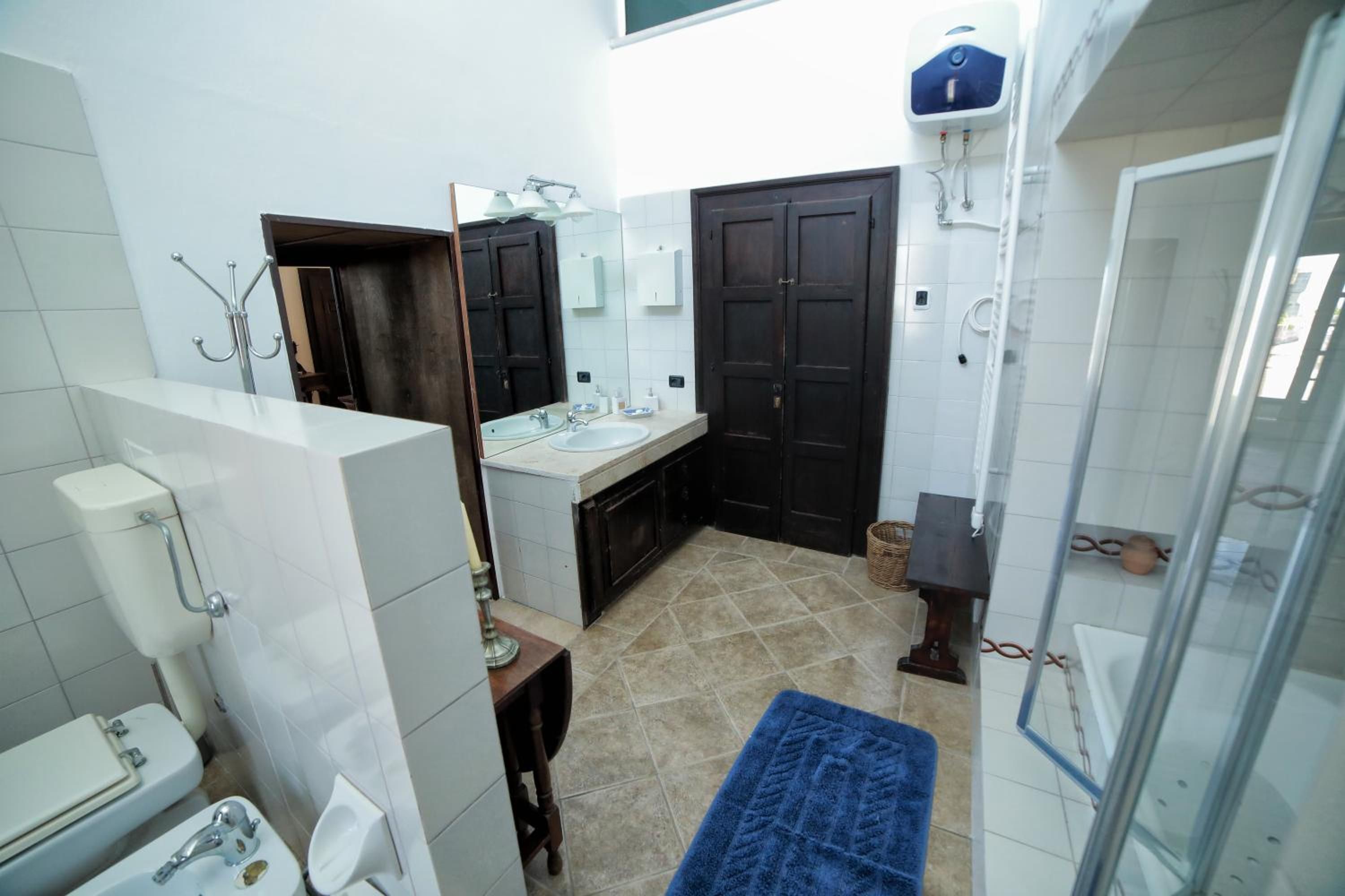 Une salle de bain comprenant des toilettes, un lavabo, un miroir et une douche.