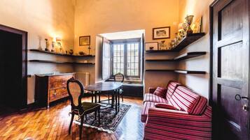 Une pièce avec un plancher en bois, une table à manger avec des chaises, un canapé et une fenêtre donnant sur un beau paysage.