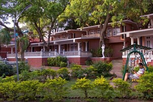 A residential building with multiple balconies, a well-maintained garden, and a swing set.