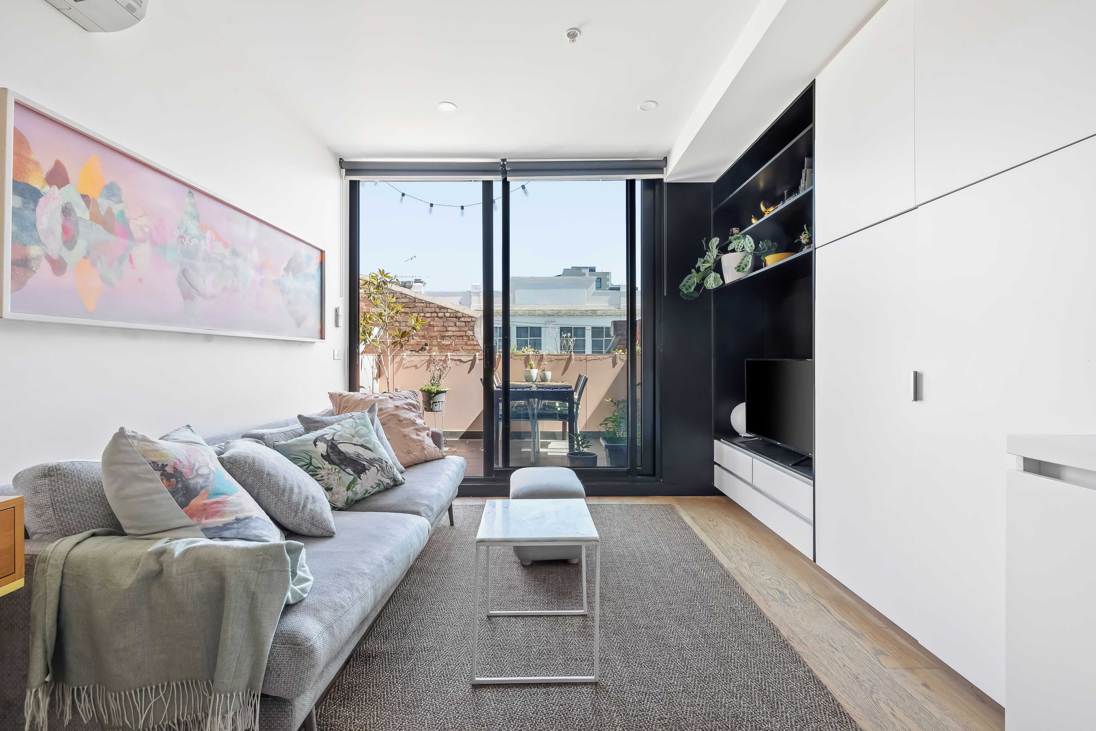 A modern living room with a sofa, coffee table, and a TV.