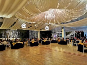 A banquet hall with tables arranged for dining, chandeliers, and draped fabric on the ceiling. - Resort y Balneario Los Angeles (Taxco)