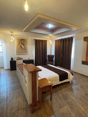 A hotel room with a bed, a desk, a chair, and a painting on the wall. - Resort y Balneario Los Angeles (Taxco)