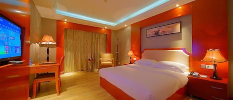 A hotel room with a bed, desk, chair, television, and a painting on the wall.