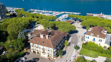 Un hôtel en bord de mer, avec plusieurs étages, une marina avec des bateaux et une vue sur la mer.