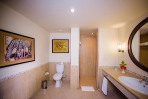 A bathroom with a toilet, sink, and shower. There are framed pictures on the wall. - Carols Beau Rivage Matrouh (Marsa Matrouh)