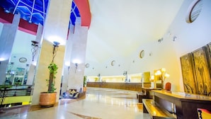 A hotel lobby with a reception desk, seating area, and a large plant. - Carols Beau Rivage Matrouh (Marsa Matrouh)